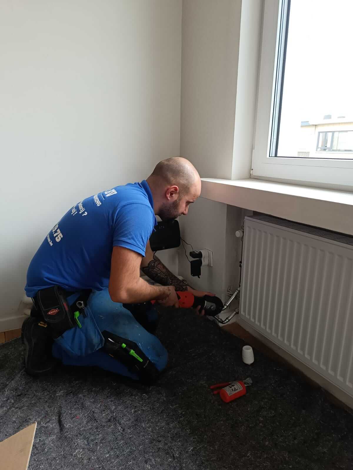 Vakman van LG & CO sluit een radiator aan bij een klant thuis